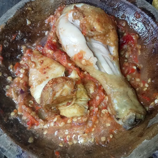 Letakkan ayam goreng di atas sambal dan penyet menggunakan ulekan, kemudian siap disajikan.