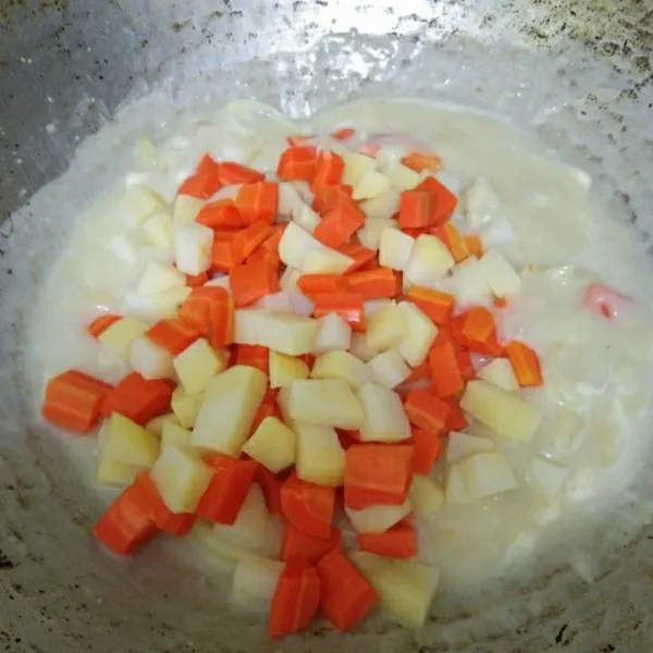 Masukkan kentang dan wortel, lalu aduk rata.