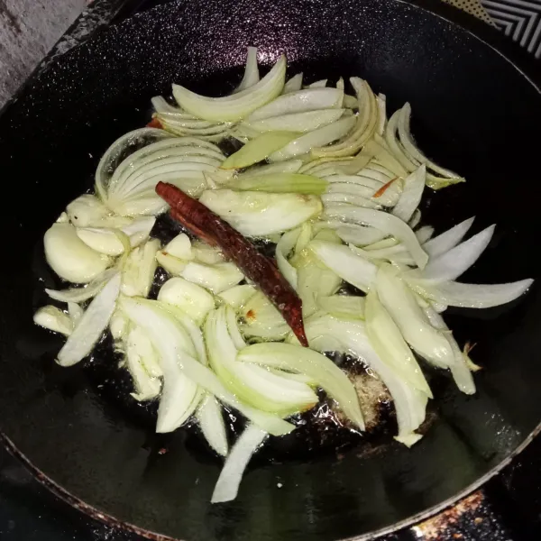 Tumis bawang bombay, bawang putih, jahe, dan kayu manis hingga harum.
