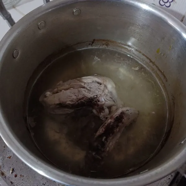 Rebus ayam sampai matang, lalu tiriskan dan buang airnya.