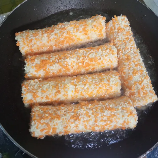 Kemudian goreng roti isi sosis hingga kecokelatan di semua sisinya. Angkat dan tiriskan, lalu potong menjadi beberapa bagian, beri topping saus tomat dan mayonaise, lalu siap dinikmati.