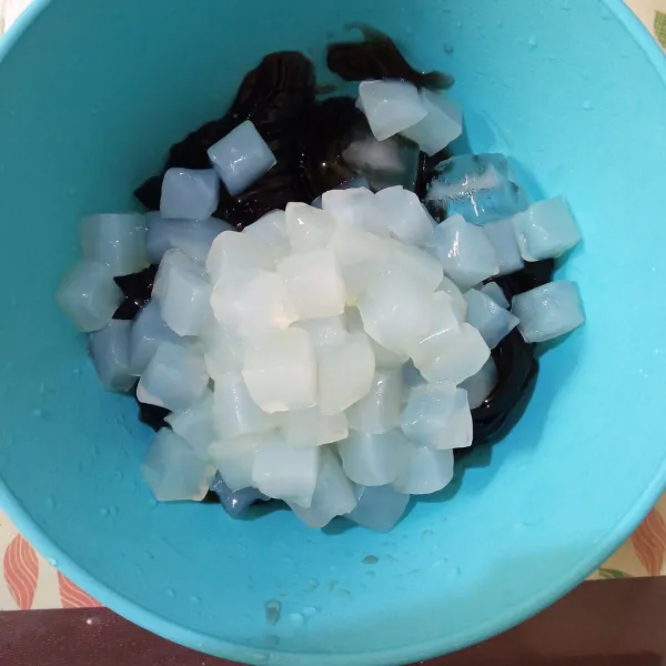 Dalam wadah, masukkan es batu, cincau hitam, dan nata de coco.
