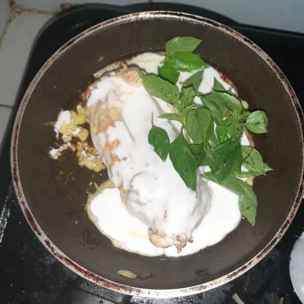 Tuang santan ke ayam dan beri kemangi, gunakan api kecil. Masak hingga santan mengental dan kemangi layu, sisihkan.