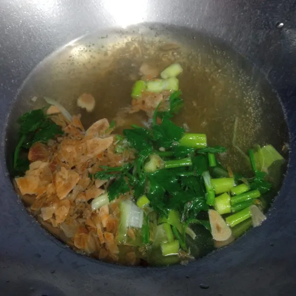 Untuk membuat kuahnya, didihkan air, setelah itu masukkan bawang merah goreng, bawang putih goreng, seledri dan irisan daun bawang.