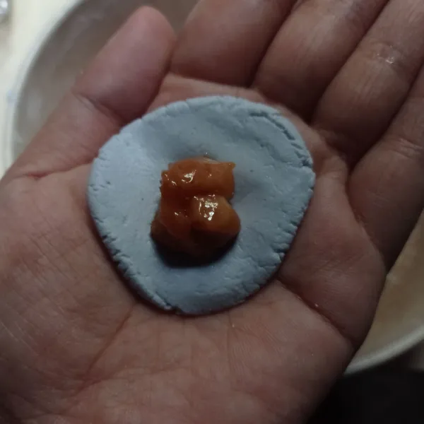 Ambil 1/2 sdm adonan pipihkan isi dengan irisan gula merah.