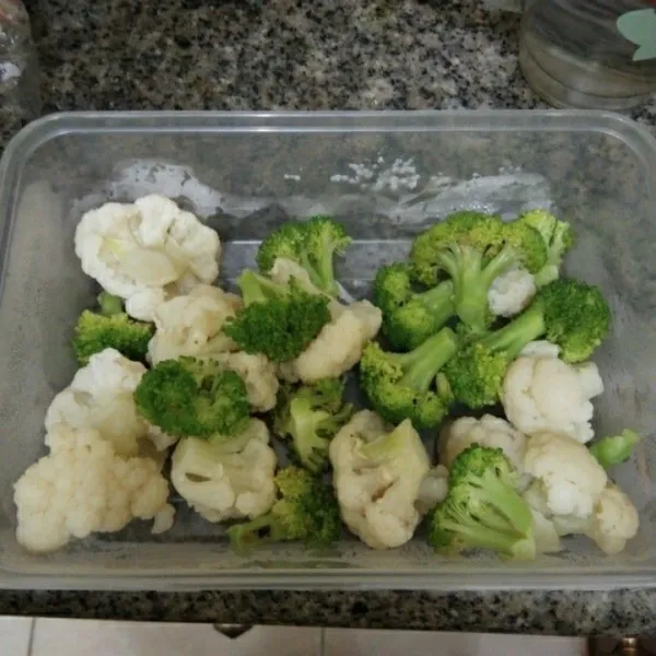 Rebus brokoli dan bunga kol sebentar saja, lalu tiriskan.