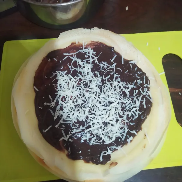 Beri isian vla coklat, ratakan dan taburi dengan parutan keju cheddar lalu lipat. Angkat dan sajikan.