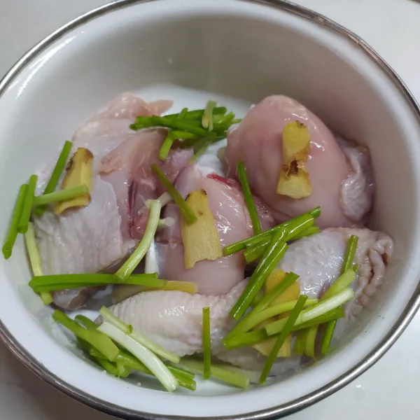 Pindahkan ke dalam wadah tahan panas, beri irisan jahe dan irisan daun bawang di sela-sela potongan ayam.