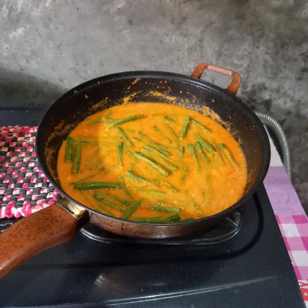 Masukkan air dan kacang panjang. Bumbui dengan garam, gula, dan penyedap rasa lalu aduk-aduk dan koreksi rasa.