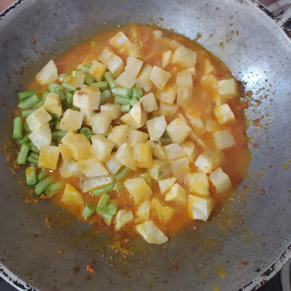 Tuang air, setelah mendidih masukkan buncis. Masukkan kentang dan bumbui dengan garam, gula merah, dan kaldu bubuk, lalu aduk rata.