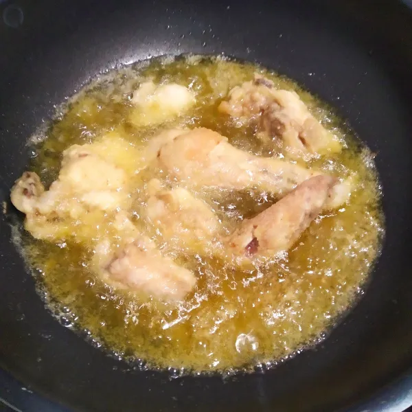 Panaskan minyak goreng, kemudian goreng ayam hingga berwarna kuning kecoklatan atau sampai matang, angkat lalu tiriskan.