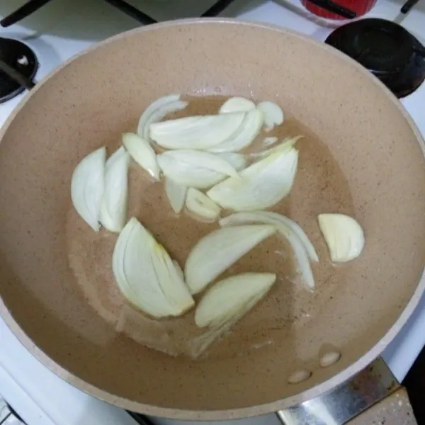 Panaskan minyak, tumis irisan bawang putih dan bawang bombay hingga harum.
