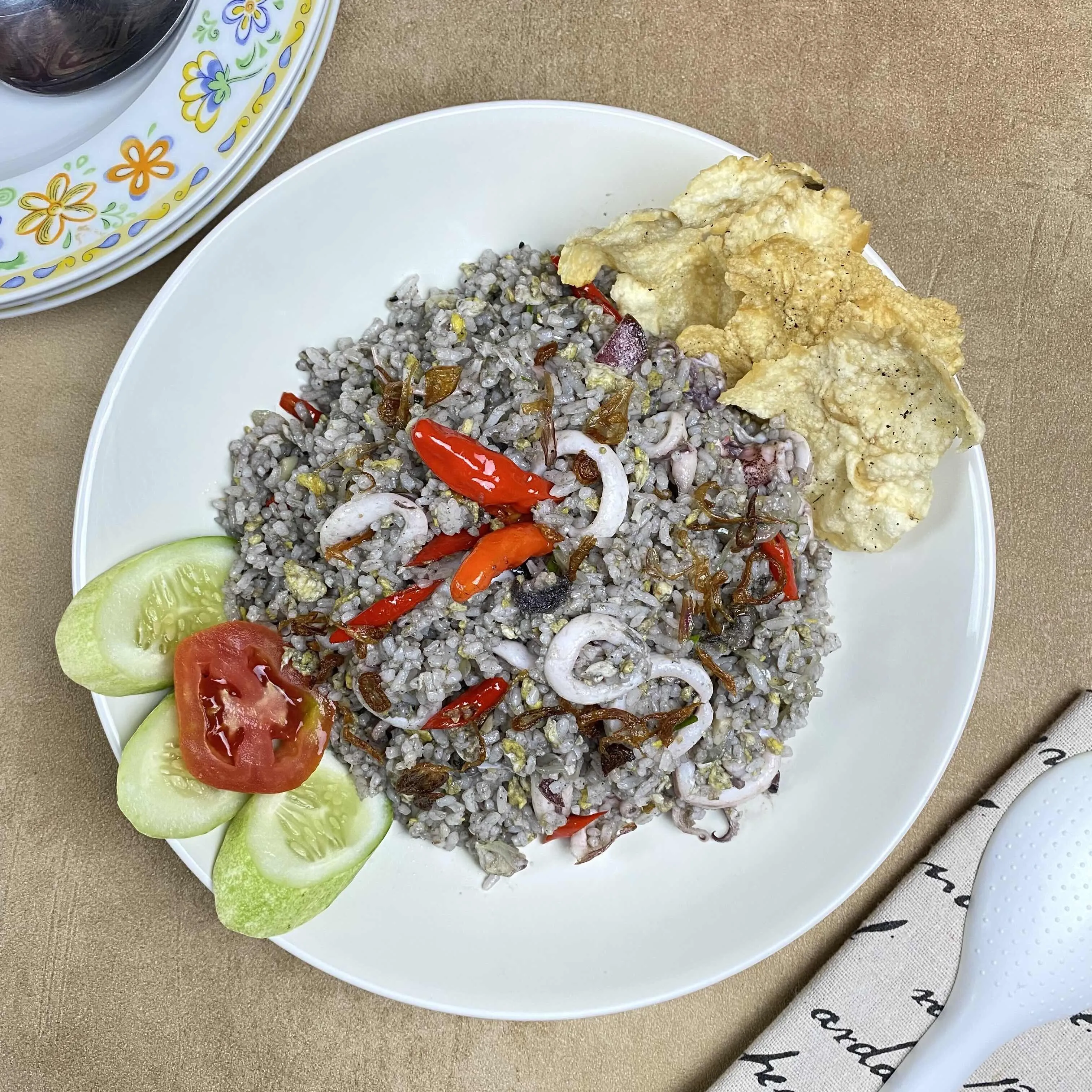 Cumi kuah hitam dalam piring saji dengan nasi putih
