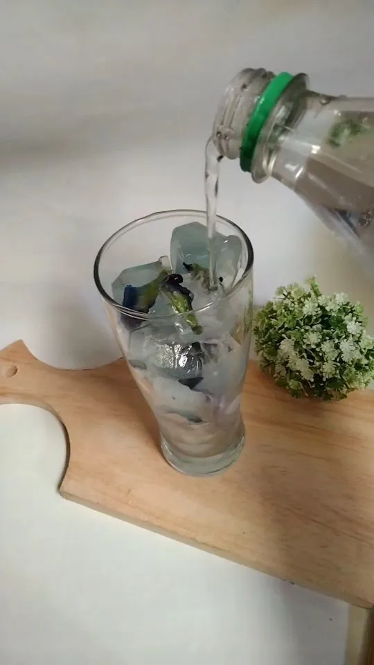 Setelah gelas terisi dengan es batu, kemudian ambil sprite (air soda) dan tuangkan ke dalam gelas secukupnya.