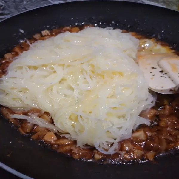 Masukkan bihun, kecilkan api, aduk hingga merata.