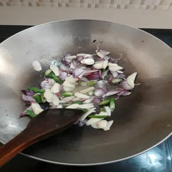 Panaskan minyak goreng. Tumis bawang merah, bawang putih dan cabai rawit sampai layu dan wangi.