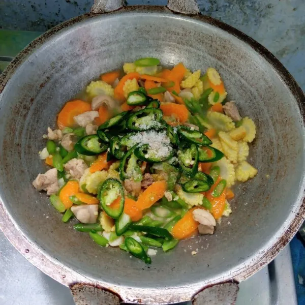 Tambahkan gula pasir, garam, lada bubuk, air, dan cabai hijau besar, aduk rata. Masak sampai matang dan cicipi rasanya. Lalu angkat dan sajikan.