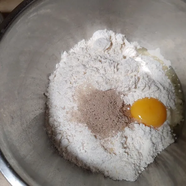 Masukan gula,ragi dan kuning telur kedalam campuran tepung terigu. lalu diaduk hingga tercampur rata.