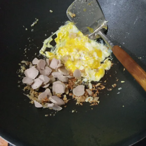 Masukkan irisan bakso dan 2 butir telur kocok. Aduk rata dan buat orak-arik.