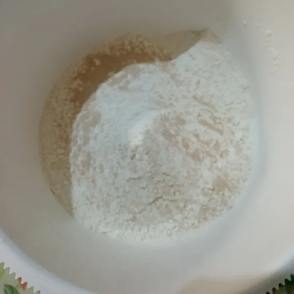 Dalam wadah masukkan tepung, ragi, susu bubuk, dan gula, aduk sampai rata.