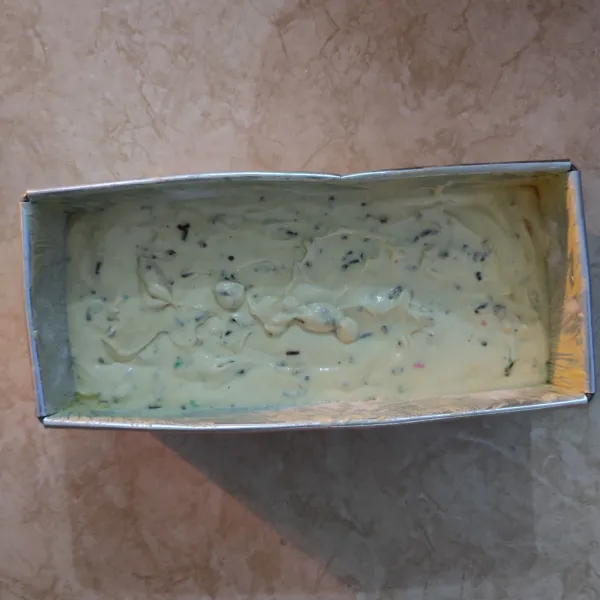 Olesi loyang dengan margarin dan taburi dengan sedikit tepung terigu, lalu masukkan adonan dan hentak-hentakkan.