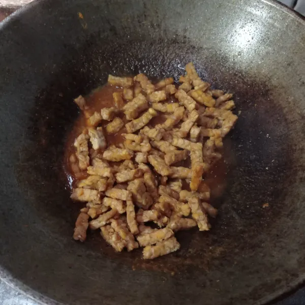 Lalu masukan tempe yang sudah digoreng, aduk sampai benar benar tercampur rata, masak sampai bumbu meresap dan air menyusut.