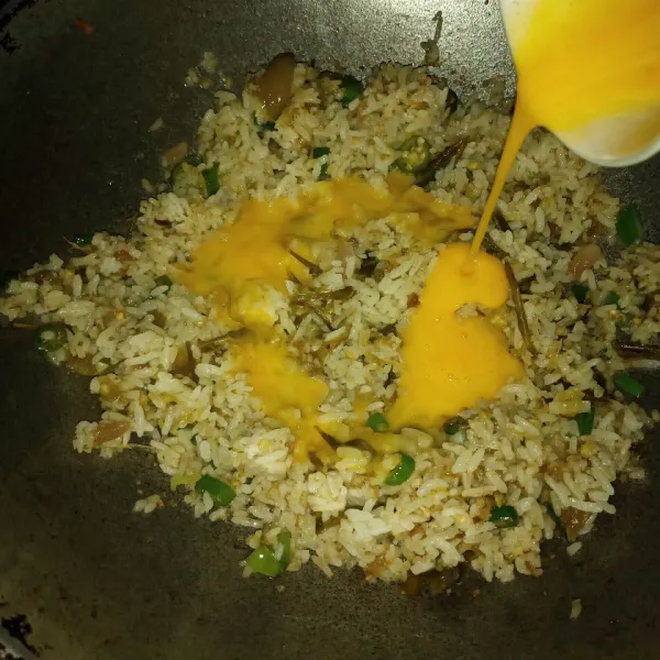 Tuang kocokan telur, aduk cepat sampai nasi berbulir kembali.