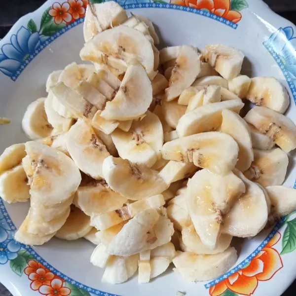 Kupas dan potong-potong buah pisang.