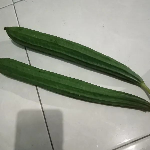 Siapkan gambas, lalu kupas kulitnya.