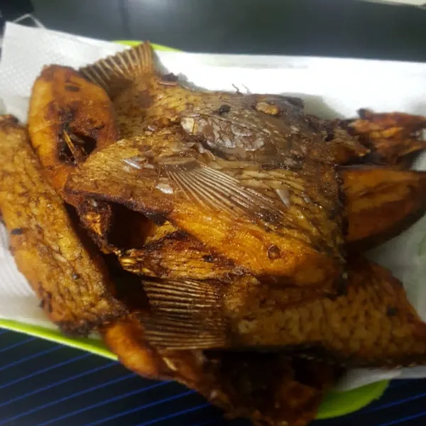 Bumbui ikan sebelum digoreng menggunakan, 2 siung bawang putih yang di cincang halus, 2 sendok makan saus tiram, 2 sendok makan kecap asin, dan setengah sendok teh garam. Jangan lupa tambahkan perasan jeruk nipis dan juga lada/merica bubuk, diamkan kurang lebih 15-30 menit hingga bumbu meresap, kemudian goreng hingga kecoklatan.