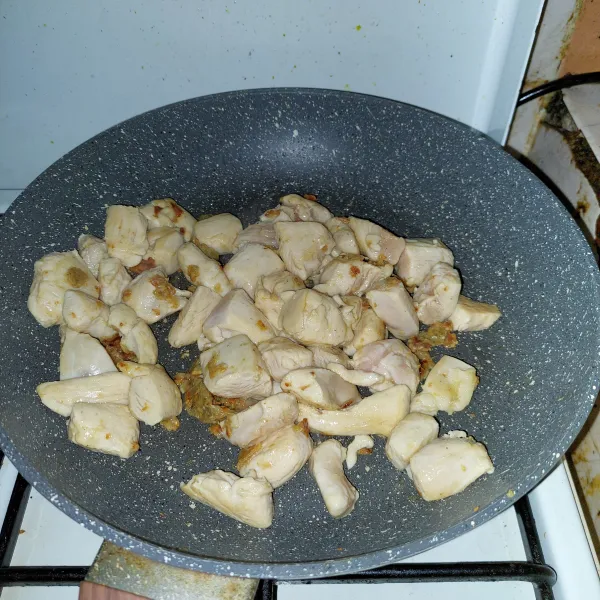 Tumis bumbu halus hingga harum dan matang, masukkan daging ayam, masak hingga berubah warna.