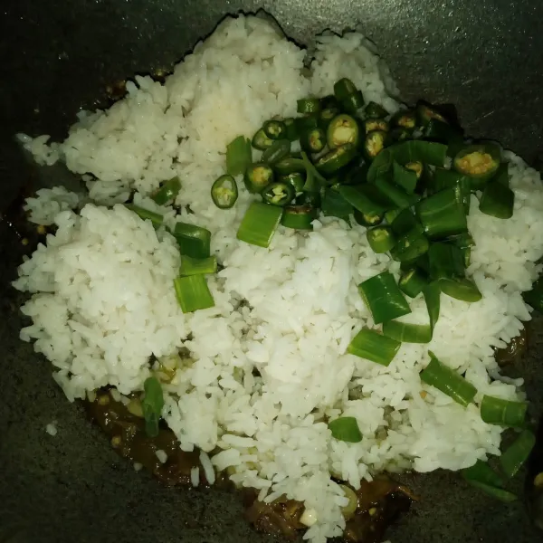 Besarkan api kompor masukkan nasi, cabe hijau dan sisa daun bawang. Bumbui garam secukupnya.