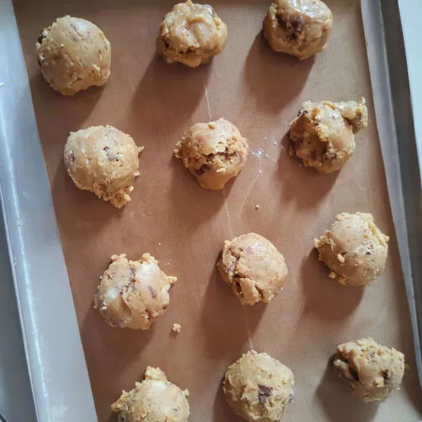 Siapkan loyang, alasi dengan silicone baking mat lalu ambil adonan masing-masing 10 gram, bulatkan dan tata di loyang.