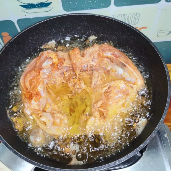 Siapkan minyak banyak, panaskan, goreng ayam hingga setengah garing di kedua sisi, angkat, diamkan 10 menit.