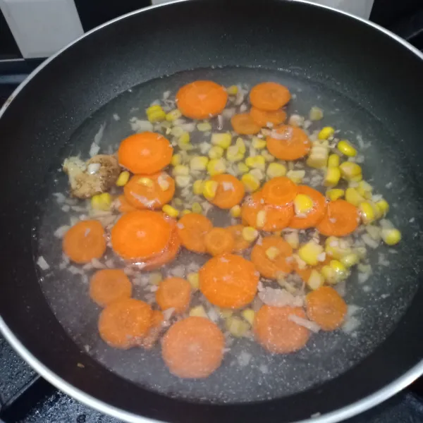 Masukkan potongan wortel dan jagung serut.
