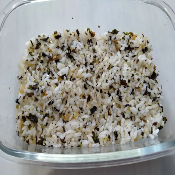 Salin nasi ke dalam piring tahan panas / loyang, lalu padatkan.