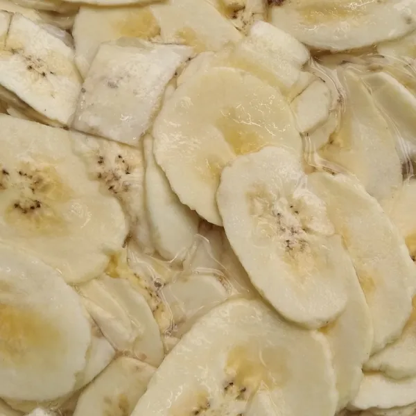 Cuci irisan pisang dengan pelan-pelan supaya tidak patah, dan rendam dengan garam dan gula selama 15 menit.