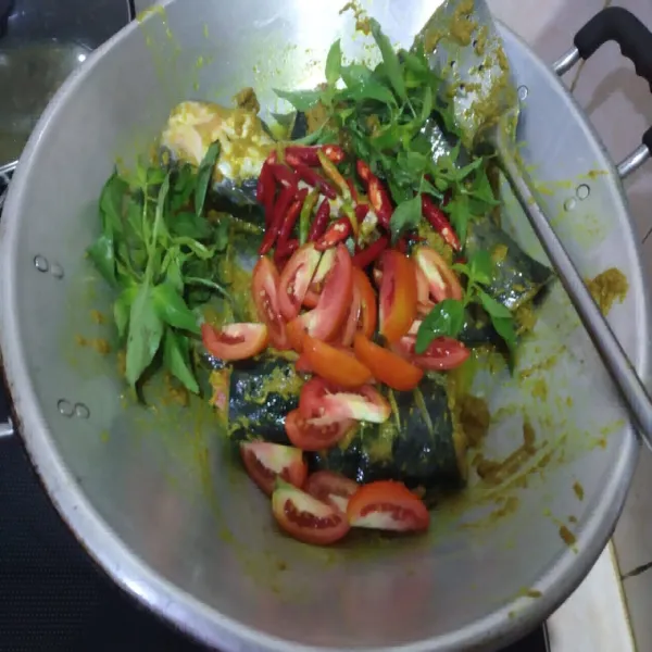 Masukkan tomat, cabe rawit utuh, irisan cabe keriting, dan daun kemangi aduk rata.