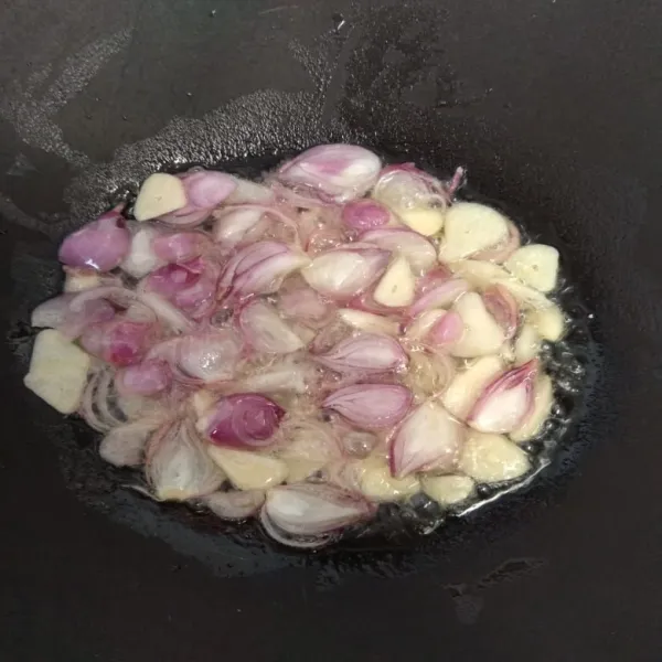 Panaskan minyak goreng, lalu tumis bawang merah dan bawang putih hingga harum.
