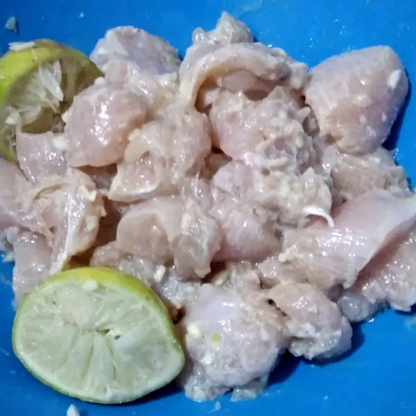 Lumuri ayam yang sudah dipotong-potong dengan bawang putih, air perasan lemon, garam, merica dan kecap ikan. Aduk rata lalu diamkan selama 15 menit di dalam kulkas.