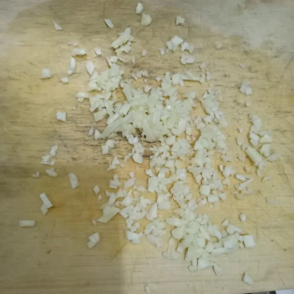 Kupas bawang putih lalu cincang.