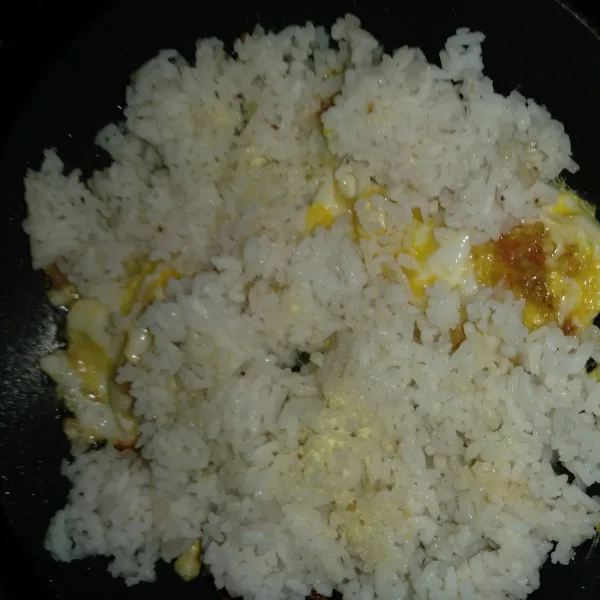 Masukkan nasi putih beri kaldu bubuk. Aduk merata dengan bumbu.