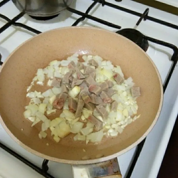Tumis bawang putih dan bawang bombay hingga harum, lalu masukkan potongan bakso dan aduk rata.