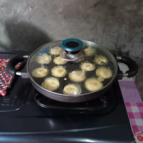 Tuang adonan ke dalam cetakan yang sudah panas. Tambahkan irisan pisang di atasnya. Panggang dengan api kecil sampai matang.