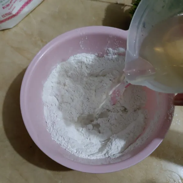 Tuang ke dalam campuran tepung secara bertahap sambil diuleni.
