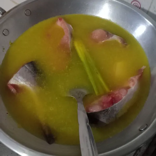 Tambahkan air, masukkan ikan patin, lalu biarkan mendidih.