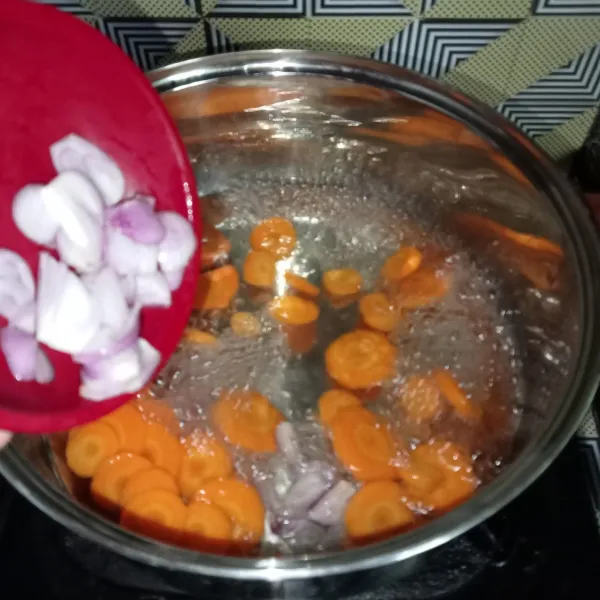 Rebus wortel dan air, setelah mendidih, masukkan irisan bawang merah.