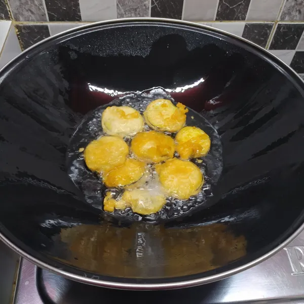 Panaskan minyak goreng, lalu goreng terong sampai matang. Angkat dan tiriskan, lalu sisihkan.