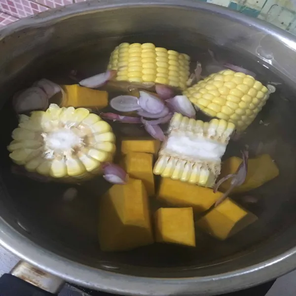 Rebus bawang merah, jagung, dan labu kuning hingga empuk.