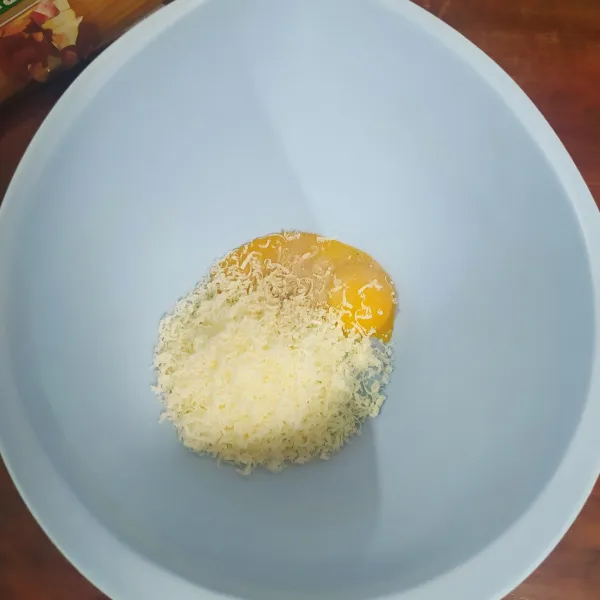 Masukkan 3 kuning telur ke dalam mangkuk, beri garam, lada bubuk, dan gula pasir. Masukkan keju cheddar yang di parut halus.